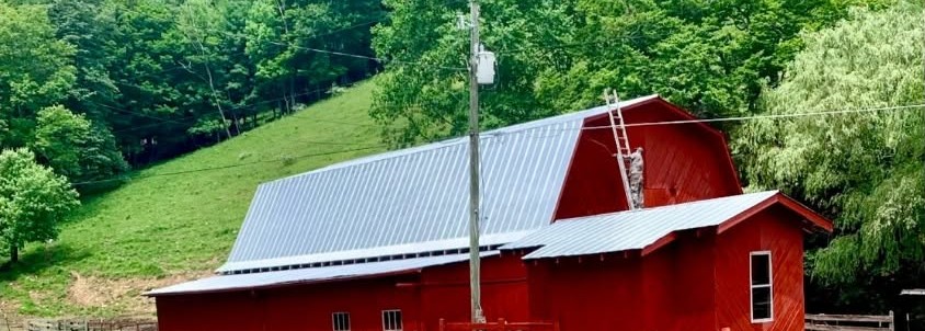 Restored red barn with new protective roof coating